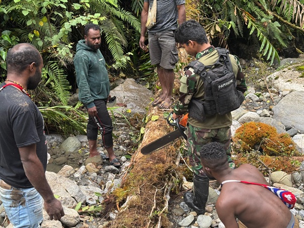 Prajurit TNI dan warga Serambakon bergotong royong membangun jembatan yang dirusak OPM