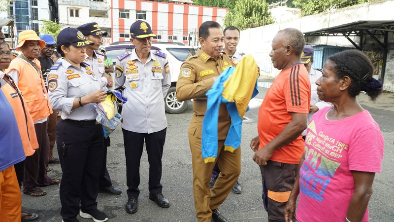 Wakil Walikota Jayapura Rustan Saru mengenakan seragam resmi kepada petugas parkir di wilayah Distrik Jayapura Utara